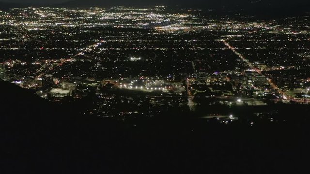 AERIAL: Flight over Hollywood Hills at Night with view on Valley , Burbank and City Lights 