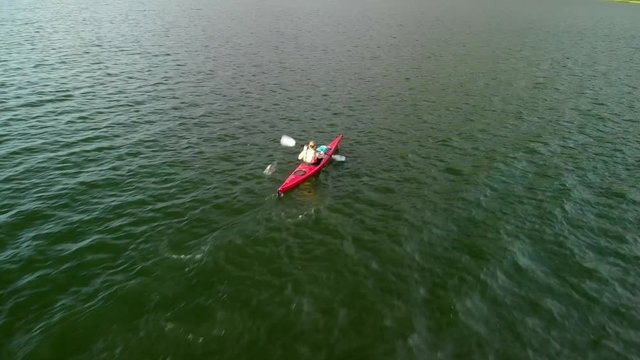 4K aerial drone man paddling in kayak in lake in Northern Norway