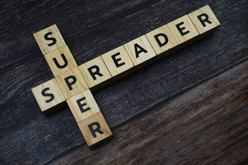 Super Spreader word letter on wooden background