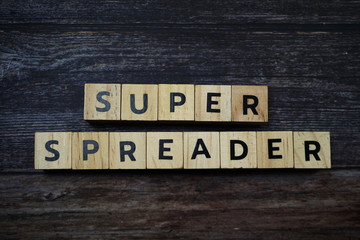 Fototapeta premium Super Spreader word letter on wooden background