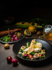 Chicken salad with traditional natural fruit and vegetable ingredients on color, black plate and table top.