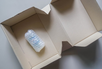 goods in bubble wrapping sheet in cardboard carton for shipment