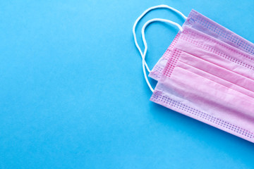 Pink medical mask, Medical protective mask on blue background. Coronavirus hygiene concept