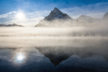 Mountain lake with reflection and fog at sunrise in Jasper National Park, Alberta, Canada
The clouds and sun reflect off the calm waters.
Famous best place in the world for summer holidays.