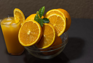 Navel oranges sliced in glass bowl and glass of orange juice