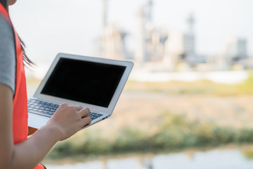 Close up of hand engineer woman working with computer laptop at power plant in outdoors.