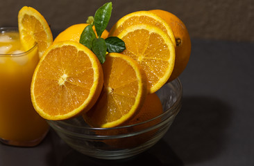 Navel oranges sliced in glass bowl and glass of orange juice