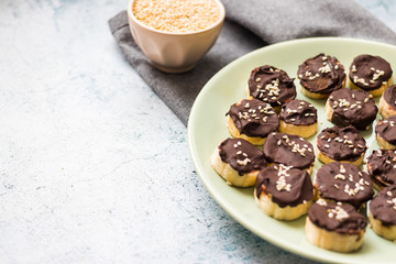 Banana slices in melted chocolate with sesame seeds. Vegan sweet healthy dessert.