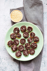 Banana slices in melted chocolate with sesame seeds. Vegan sweet healthy dessert.