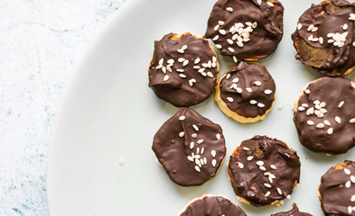 Banana slices in melted chocolate with sesame seeds. Vegan sweet healthy dessert.