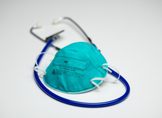 Protective Respirator on Top of Blue Stethoscope