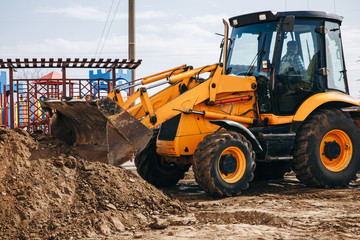 Digger machine digging and removing earth in construction site