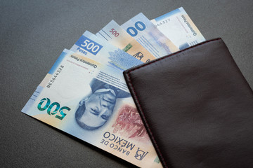 Mexican 500 pesos pile of blue bucks inside a wallet background close up