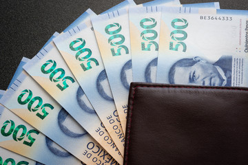 Mexican 500 pesos pile of blue bucks inside a wallet vertical
