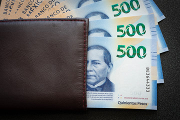 Mexican 500 pesos pile of blue bucks inside a wallet watching dollar