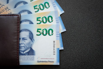 Mexican 500 pesos pile of blue bucks inside a wallet with eye sight