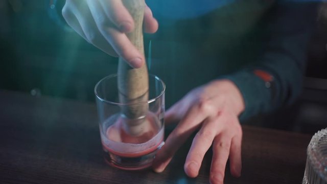 bartender preparing traditional old fashioned cocktail with whiskey and orange