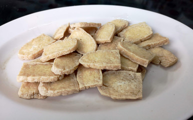Fried slided soybean cake on white plate in closeup picture