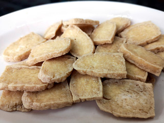 Fried slided soybean cake on white plate in closeup picture