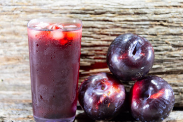 Plum juice (Prunus sp.) Served in a glass with ice and fresh fruits