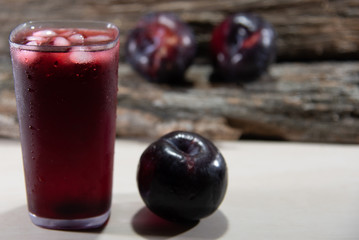 Plum juice (Prunus sp.) Served in a glass with ice and fresh fruits