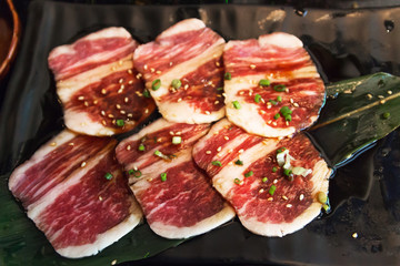 Premium raw beef sliced set; wagyu, chuck, tongue tenderloin, strip loin, rib eye, karubi on black plate with onion sliced: Different types of raw meat high quality for grill (barbecue or yakiniku).