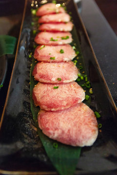 Premium raw beef sliced set; wagyu, chuck, tongue tenderloin, strip loin, rib eye, karubi on black plate with onion sliced: Different types of raw meat high quality for grill (barbecue or yakiniku).