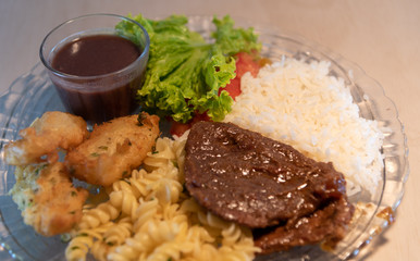 Popular dish of Brazilian food with rice beans pasta with meat and salads