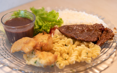 Popular dish of Brazilian food with rice beans pasta with meat and salads
