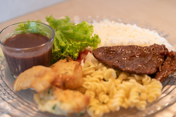 Popular dish of Brazilian food with rice beans pasta with meat and salads
