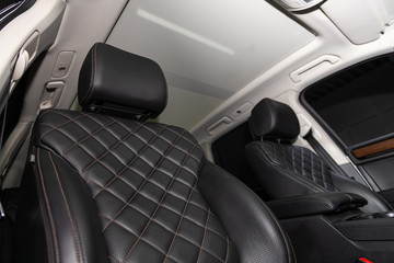 Salon of a new stylish car. Auto interior: driver and passenger seats in black leather.