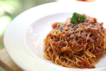 spaghetti Bolognese with minced beef and tomato sauce garnished with parmesan cheese and basil , Italian food