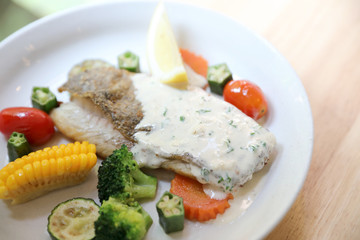 Sea bass fillet , baked sea bass with lemon sauce on wood background