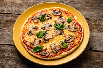 Freshly making pizza with mushrooms served on the rustic background. Selective focus. Shallow depth of field.