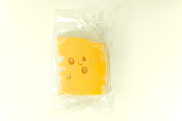 a piece of cheese in a vacuum pack isolated on white background