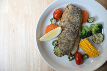 Sea bass fillet , baked sea bass with lemon sauce on wood background