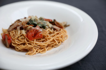 spaghetti Bolognese with minced beef and tomato sauce garnished with parmesan cheese and basil , Italian food