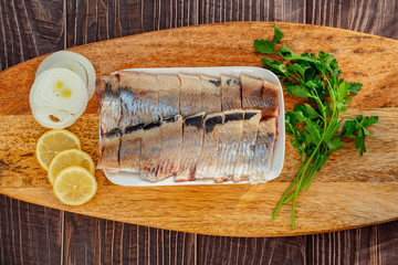 top view sliced salted herring plate onion lemon 