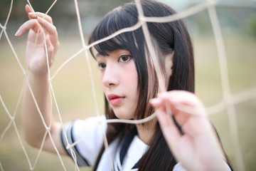 Portrait of beautiful Asian japanese high school girl uniform looking with net