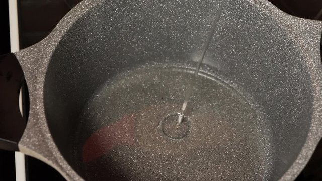 Pouring cooking oil on the frying pan - Top View