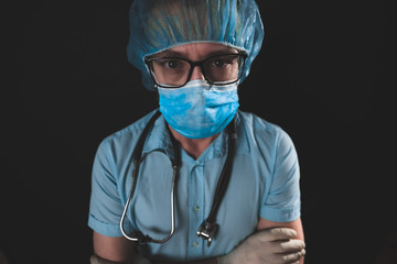Medical doctor, nurse, surgeon, psychologist working with protective mask, glasses and gloves helping people in the days of panic, pandemic - studio shot on black background.