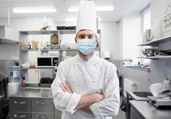 health protection, safety and pandemic concept - male chef cook wearing face protective medical...