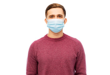 health, quarantine and pandemic concept - young man wearing protective medical mask for protection...