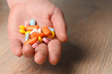 Several colored tablets in hand close-up. Concept of assistance in case of illness. Help with viral infection.