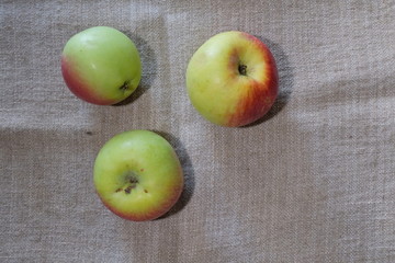 beautiful apples on a light background of burlap on the fruit, dents are visible during transportation