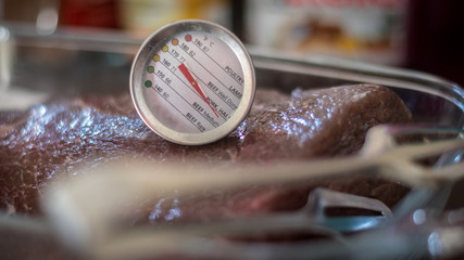 Isolated close up of a delicious beef Picanha meat loaf roasting on a hot grill with a temperature gauge- Israel