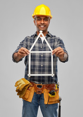 measurement, construction and building - happy smiling indian worker or builder in helmet with folding ruler in shape of home over grey background