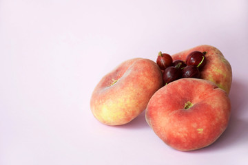 Healthy and wholesome food concept, minimalism. Ripe bright fruits on a pink background with copy space for text. Three fresh figs and agrus with selective focus.