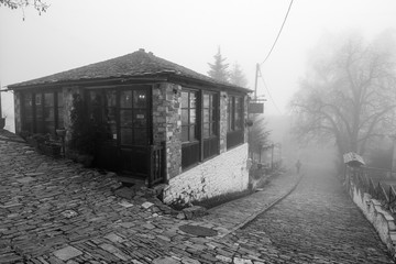 Naklejka na ściany i meble Fog and traditional stone building in Vizitsa village on mountain Pelion.Greece