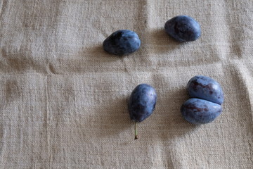 plums of different sizes on a light background of burlap healthy food vitamins
